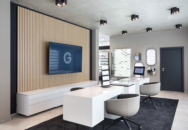 Moderner Beratungsbereich von Gollach Optik in Iphofen – stilvolle Innenarchitektur mit Beratungstischen, großer Brillenauswahl und digitaler Messtechnik. Hier können Sie Ihren Optiker-Termin in Iphofen bequem vereinbaren