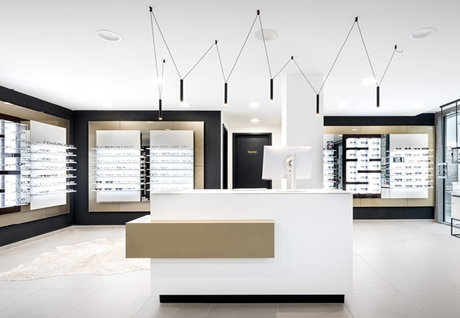 Moderner Empfangsbereich der Gollach Optik Filiale in Gerbrunn mit großer, hochwertiger Brillenausstellung – ideal für Terminvereinbarungen rund um Sehtest, Brillenberatung und Kontaktlinsen.