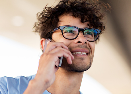 Mann mit Brille telefoniert, um einen Termin beim Optiker oder Hörakustiker zu vereinbaren – schnelle und unkomplizierte Terminbuchung in Ihrer Nähe.